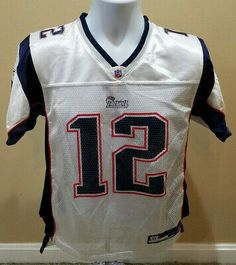 a football jersey with the number twelve on it is displayed in front of a wall