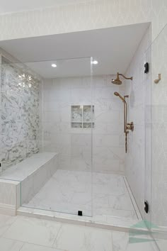 a walk in shower sitting next to a white tiled wall and floor with glass doors