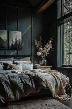 a bedroom with dark green walls and wooden flooring is furnished with an oversized bed