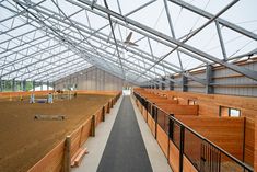 the inside of a building with wooden stalls and benches on either side of the walkway