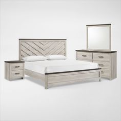 a white bed sitting next to a dresser with a mirror on it's side