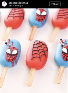 spiderman lollipops are on sticks with blue and red frosting in the shape of pops