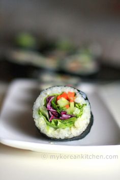 there is a sushi on the plate with lettuce, carrots and cucumber