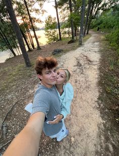 a man and woman taking a selfie in the woods