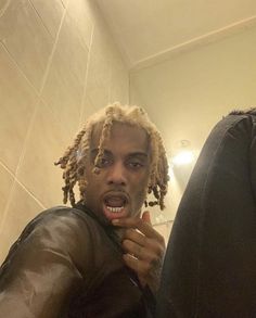 a man with dreadlocks brushing his teeth