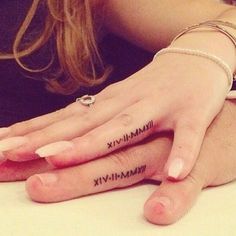 two people with matching tattoos on their hands, one holding the other's hand