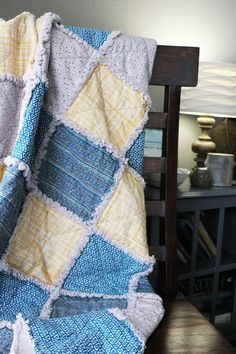 a blue and yellow blanket sitting on top of a wooden chair