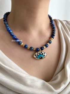 Lapis Lazuli Gold-Filled Necklace with Ceramic Evil Eye Pendant 
#handmade #evileye #lapislazuli #necklace #jewellerydesign #gemstonenecklace #gemstonejewelry #statement #statementjewelry #moonstone #aventurine #etsy #etsyseller #chunkynecklace #boho #bohemian #bohochic #etsy #etsyseller #art #design Blue Lapis Lazuli Jewelry For Festivals, Handmade Blue Amulet Beaded Necklace, Handmade Blue Lapis Lazuli Necklace, Blue Evil Eye Jewelry For Meditation, Bohemian Blue Evil Eye Jewelry, Bohemian Blue Beaded Necklaces With Evil Eye, Blue Lapis Lazuli Necklace For Meditation, Handmade Symbolic Blue Necklaces, Handmade Symbolic Blue Necklace