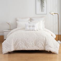 a bed with white comforters and pillows in a room