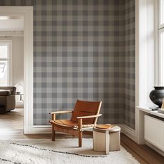 a chair and ottoman in front of a wall with a checkered pattern on it