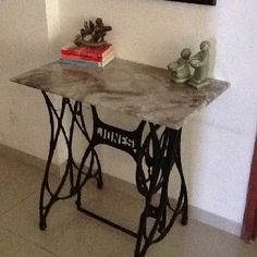 an old sewing machine is sitting on a table in front of a wall with pictures