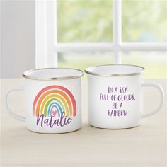 two personalized coffee mugs sitting on top of a table next to each other