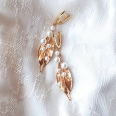 This Long gold leaf earrings dangle, made of metal leaf and pearls. This a beautiful and gorgeous  accessory for brides.  On the wedding day, every bride wants to look fantastic. This ivory pearl vine earrings will be a magical addition to your look on your happiest day.  This will emphasize the ease and sophistication of your image.  -Material- simulated pearl and crystals  -Colors- gold and white - Size - 2 inches (5 cm) -hanging part  - Unique handmade.  You deserve the best! Elegant Rose Gold Leaf Jewelry, Rose Gold Plated Pearl Earrings For Wedding, Elegant Leaf-shaped Jewelry For Party, Elegant Leaf-shaped Party Jewelry, Leaf-shaped Wedding Jewelry With Matching Earrings, Gold Metal Pearl Earrings For Wedding, Elegant Gold Plated Leaf Earrings, Elegant Leaf-shaped Metal Earrings, Elegant Leaf-shaped Wedding Jewelry