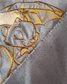 a close up view of the stitching on a jacket with an image of a cartoon character