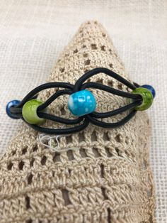 This multicolored boho style handmade beaded cord bracelet is done in colors of blues and green beads on black leather cord. It is a casual piece of jewelry that is a great gift idea for ladies or girls of any age. It is approximately 8 inches in length with a toggle clasp and is made in the USA. Other colors are available. * can also be custom ordered for a man's wrist Adjustable Black Hippie Bracelet, Adjustable Multicolor Leather Bracelet With Colorful Beads, Bohemian Multicolor Beaded Bracelets With Waxed Cord, Adjustable Black Braided Bracelet With Colorful Beads, Unique Adjustable Bracelet With Black Beads, Hippie Blue Bracelets With Round Beads, Hippie Blue Round Bead Bracelets, Handmade Black Beaded Hippie Bracelets, Adjustable Blue Beaded Bracelets In Hippie Style