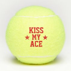 a tennis ball with the words kiss my ace written in red on it's side