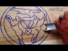 a person using a knife to cut out a cow's head on a wooden cutting board