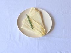 a white plate topped with napkins and a pine branch