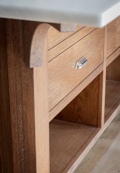 a close up of a wooden table with drawers and a white marble top on it