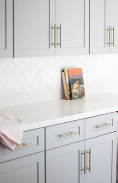 grey blue kitchen cabinets with gold hardware and white subway tile in herringbone pattern Grey And Gold Kitchen, Grey Blue Kitchen, Remodel Farmhouse, Model Dapur, Blue Kitchen Cabinets, Kitchen Backsplash Designs, Decor Ikea