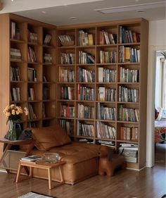 a living room filled with lots of bookshelves next to a couch and coffee table