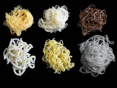 four different types of noodles on a black background