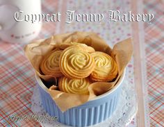 a small blue bowl filled with cookies on top of a table next to a cup