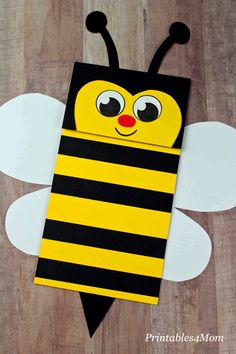 a bee craft made out of construction paper on top of a wooden floor with the words,