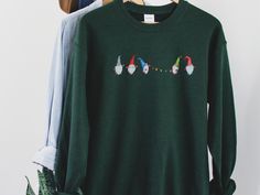 Deck the halls in this Christmas Gnome Sweatshirt featuring holiday gnomes holding Xmas lights. This is a cute and cozy sweatshirt that would also work well with your Christmas pjs! Ideal for any situation, a unisex heavy blend crewneck sweatshirt is pure comfort. These garments are made from polyester and cotton. This combination helps designs come out looking fresh and beautiful. The collar is ribbed knit, so it retains its shape even after washing. There are no itchy side seams on these sweat Christmas Sweaters Aesthetic, Gnome Sweatshirt, Holiday Gnomes, Christmas Clothes, Xmas Lights, Road Design, Christmas Pjs, Jolly Christmas, Style Aesthetic