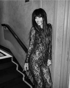 black and white photograph of woman in dress walking down stairs