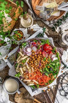 a large salad with lots of vegetables and beans in it sitting on top of a table