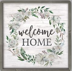 a wooden sign that says welcome home with white flowers and greenery around the frame