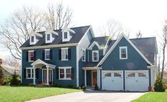 a large blue house with two garages