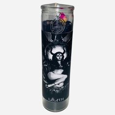 a candle that is sitting on top of a white surface with an image of a woman