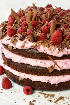 a chocolate raspberry cake with pink frosting and fresh raspberries on top