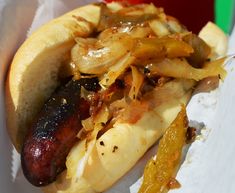 a hot dog on a bun with onions and mustard