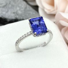 This beautiful ring is made from genuine 925 sterling silver with rhodium plating. Ring details- -The Main stone is an Emerald Cut 9mm by 7mm High Quality Lab Created Tanzanite Stone -Side stones are Round 2mm simulated diamonds -Ring is casted in solid 925 sterling silver with rhodium plating (yellow gold and rose plated also available, please check the drop down menu for more options) -The Total face height of the ring measures 10mms and the band width measures 2mms -Each ring is handmade, so Classic Gia Certified Lab-created Sapphire Rings, Classic Cubic Zirconia Radiant Cut Sapphire Ring, Tanzanite White Gold Diamond Ring With Brilliant Cut, Brilliant Cut Tanzanite Diamond Ring In White Gold, Classic Tanzanite Diamond Ring In White Gold, White Gold Tanzanite Diamond Ring With Brilliant Cut, Classic White Gold Ring With Lab-created Sapphire, Classic White Gold Rings With Lab-created Sapphire, Gia Certified Silver Sapphire Halo Ring