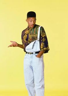 a young man in overalls is holding his hand out to the side while standing against a yellow background