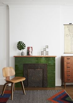 a living room with a green brick fireplace