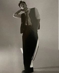 a black and white photo of a man in a suit with his hand on his head