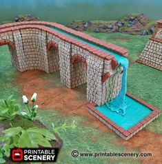 a miniature bridge made out of bricks with water running through it and flowers growing on the ground