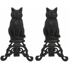 two black cat figurines with green eyes sitting on top of each other's legs