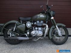 a green motorcycle parked in front of a garage door