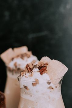 two glasses filled with ice cream and toppings on top of each other, next to one another