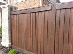 a wooden fence in front of a brick house