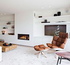 a living room with white furniture and a fire place