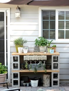 an outdoor patio area with potted plants and pots on the side of the house