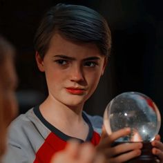 a young boy holding a crystal ball in his hands