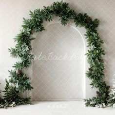 an arch made out of green leaves and pine cones