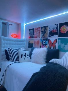 a bed with lots of pillows and pictures on the wall next to it's headboard